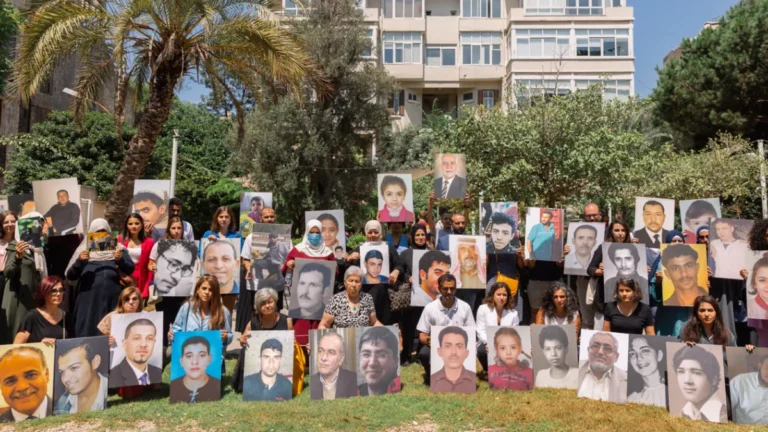 أهالي معتقلين ومختفين قسريا يحملون صور ذويهم