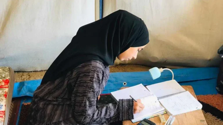 إحدة طالبات الثانوية العامة في غزة داخل إحدي خيام الإيواء